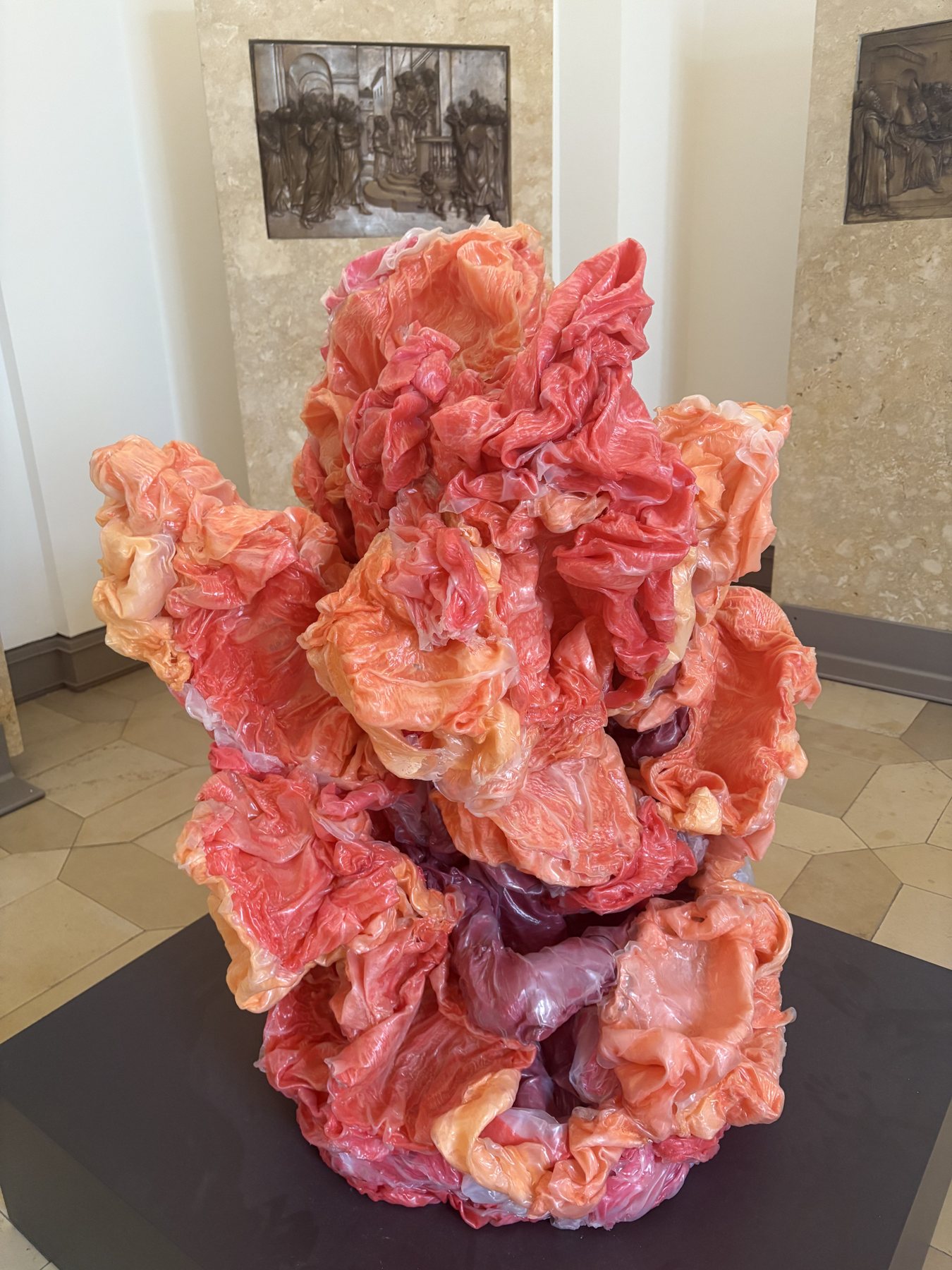 A large pink translucent contemporary sculpture in a historic museum hall