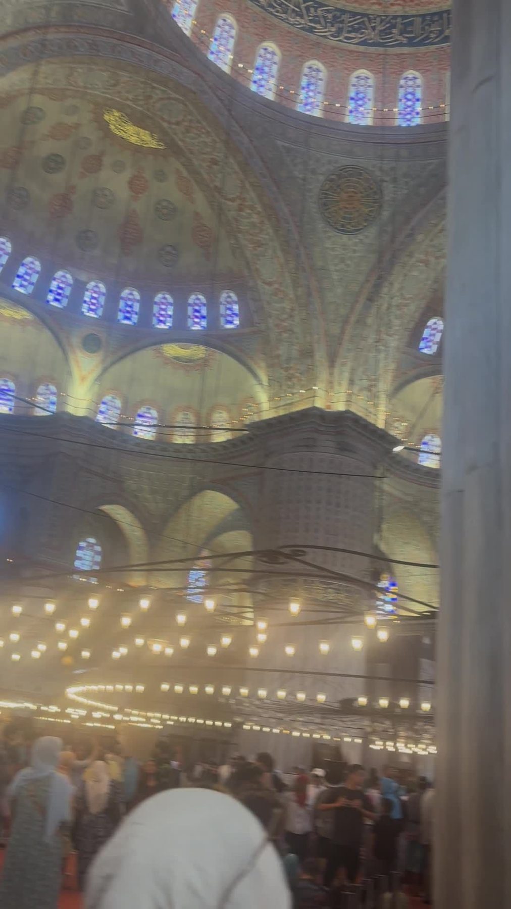 The blue tiled interior and stained glass of the Blue Mosque
