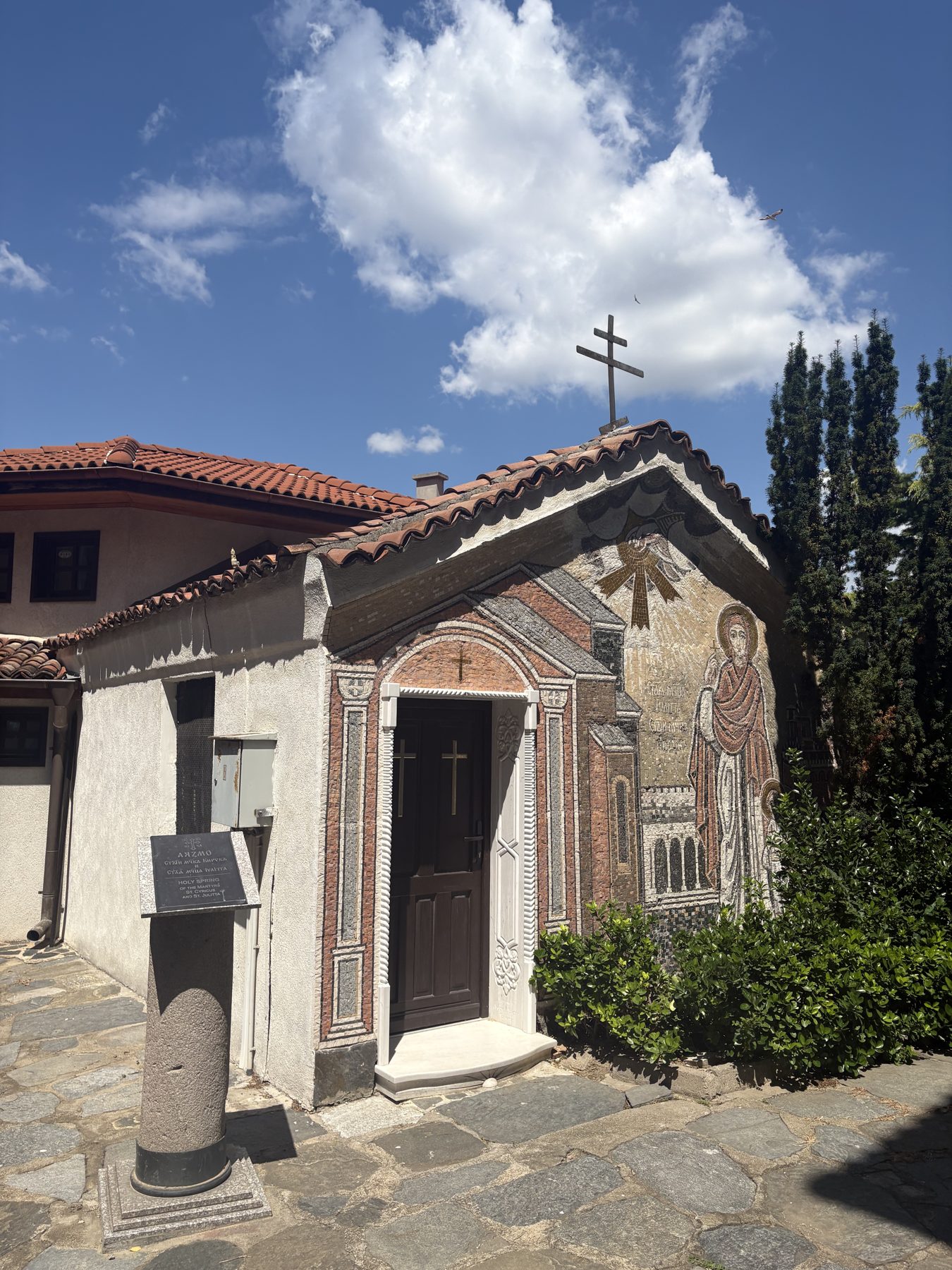 A small old stone chapel with a cross on its roof