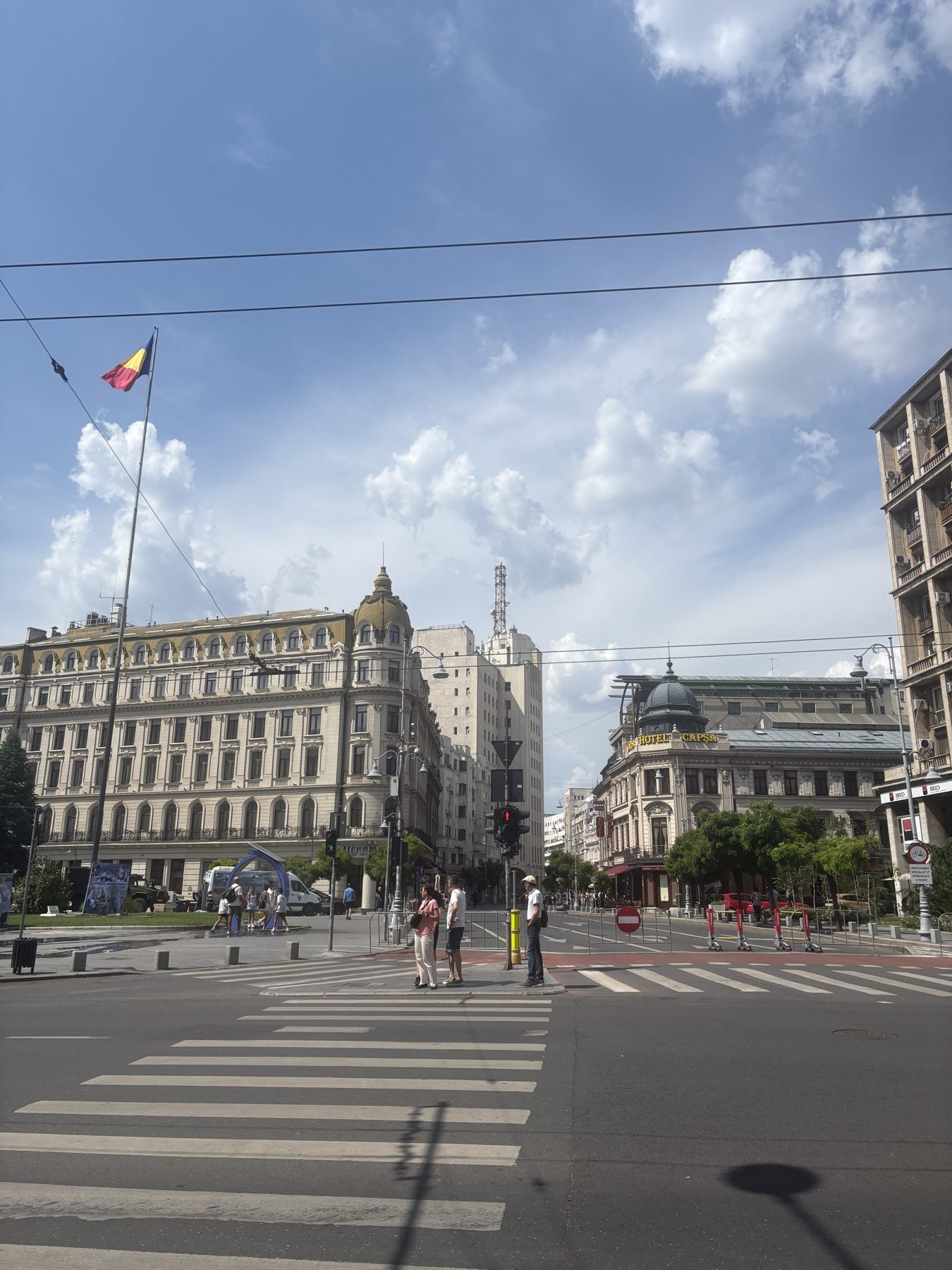 A wide Bucharest boulevard with a Romanian flag