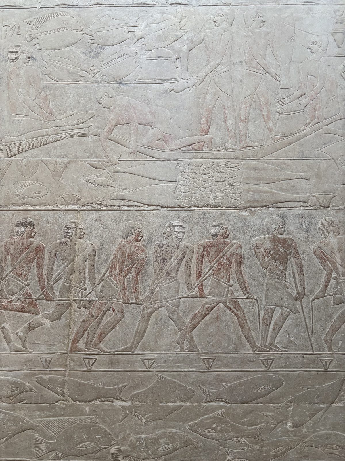 Painted relief of figures carrying offerings inside a Saqqara mastaba tomb