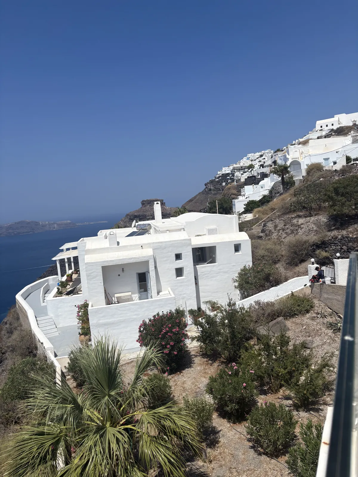 A white cliffside villa overlooking the Aegean in Santorini