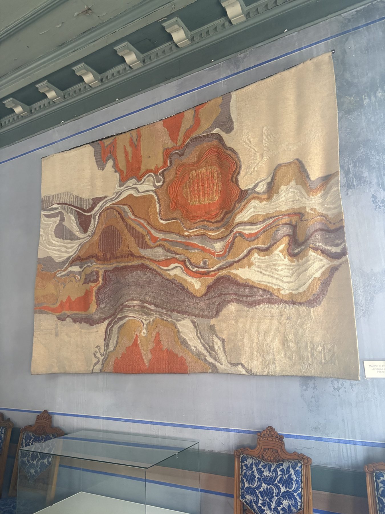 A large woven tapestry hanging in a museum hall