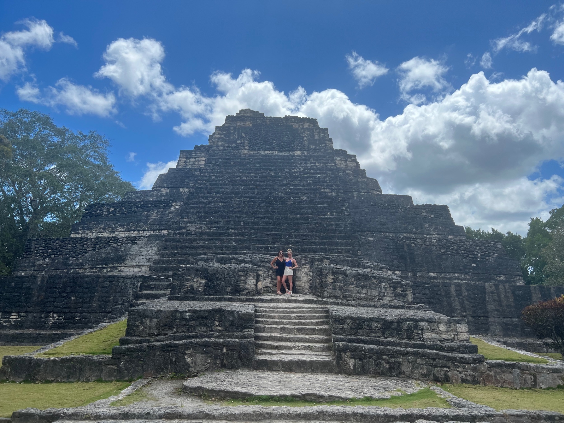 Two of us partway up the steps of the Chacchoben pyramid under big clouds