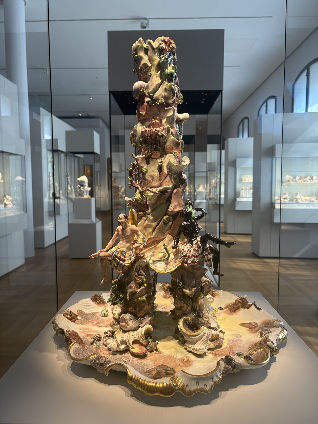 A towering tiered porcelain table centrepiece in a glass case