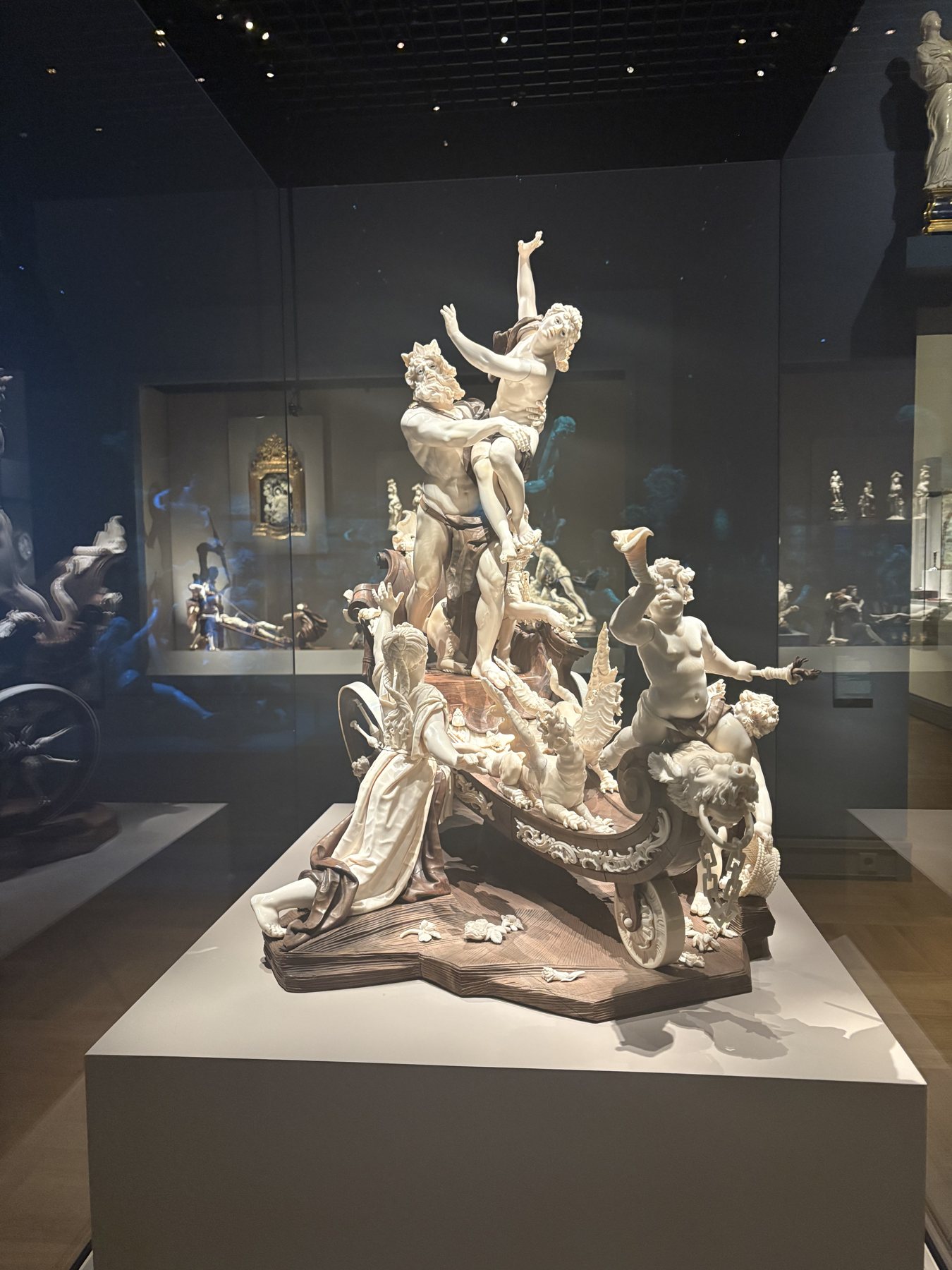 A large porcelain sculptural group of figures and horses in a museum gallery
