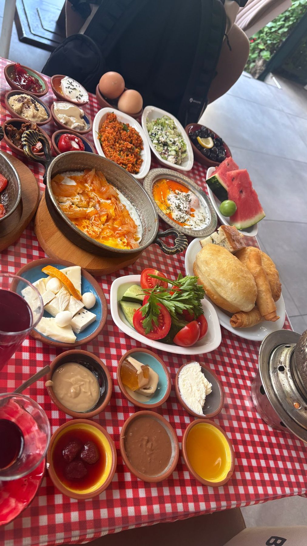 A full Turkish breakfast spread on a red checked tablecloth