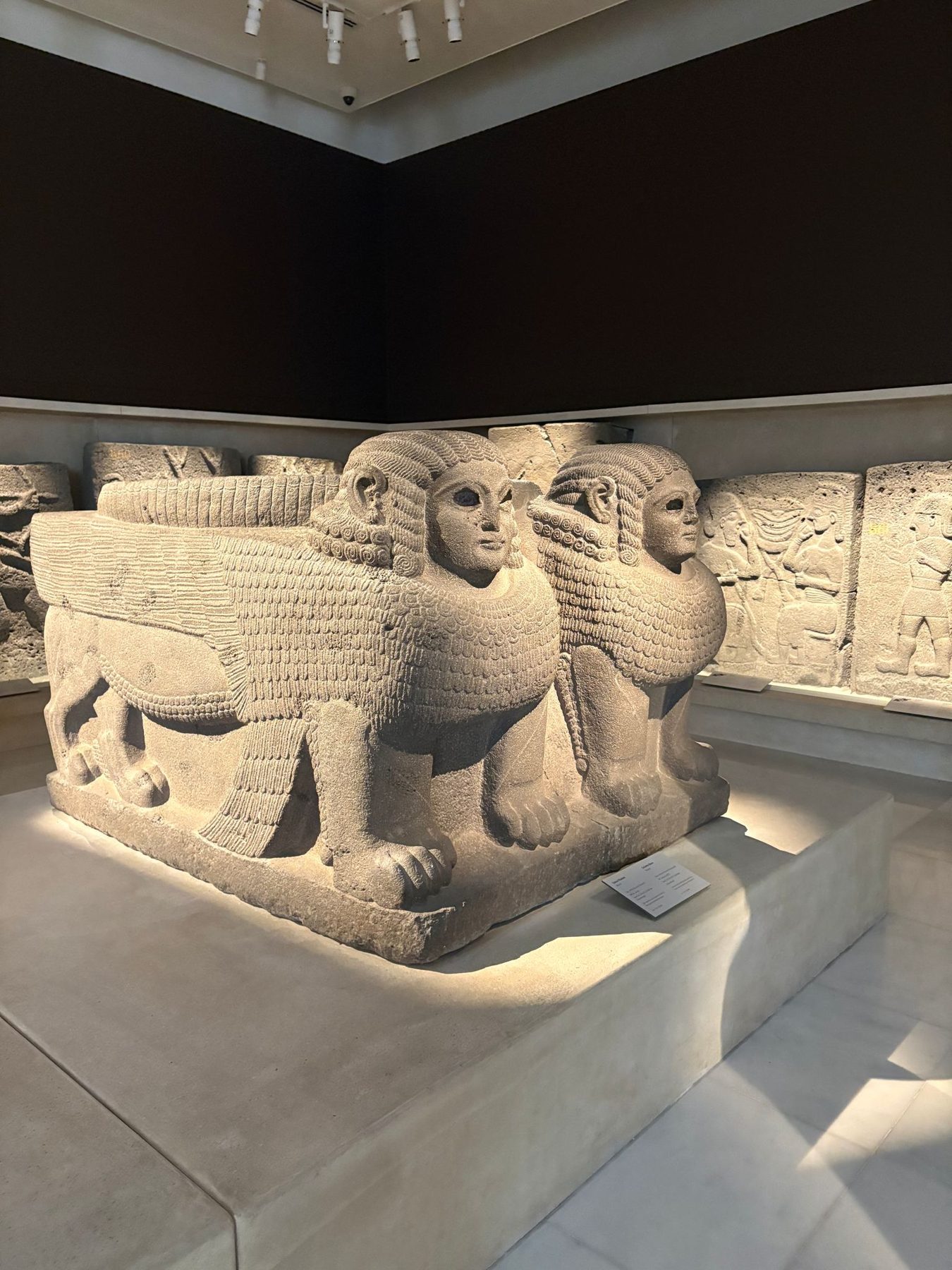 An ancient winged human-headed stone relief in a museum
