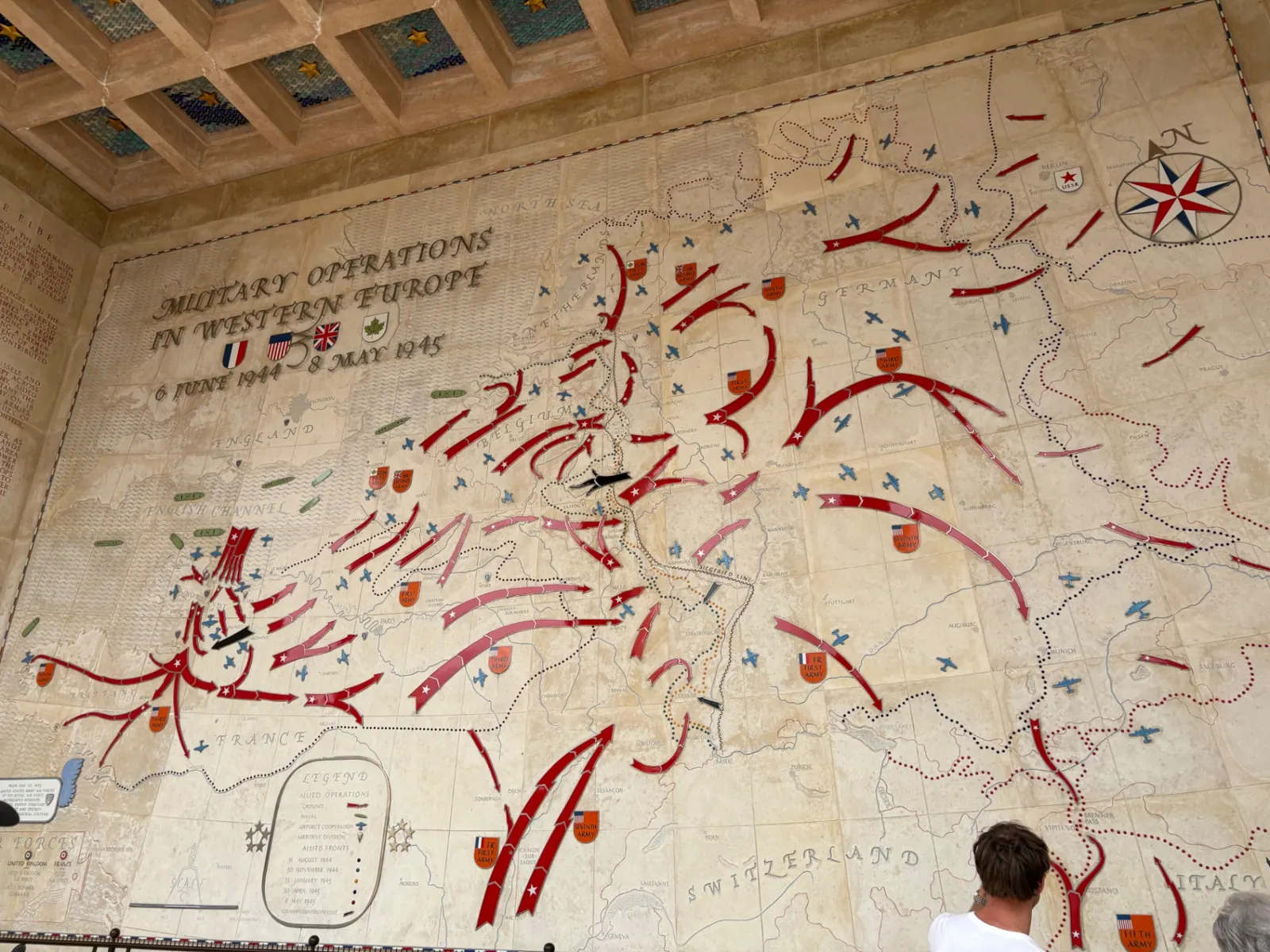 A carved stone wall map titled Military Operations in Western Europe with red arrows tracing Allied advances
