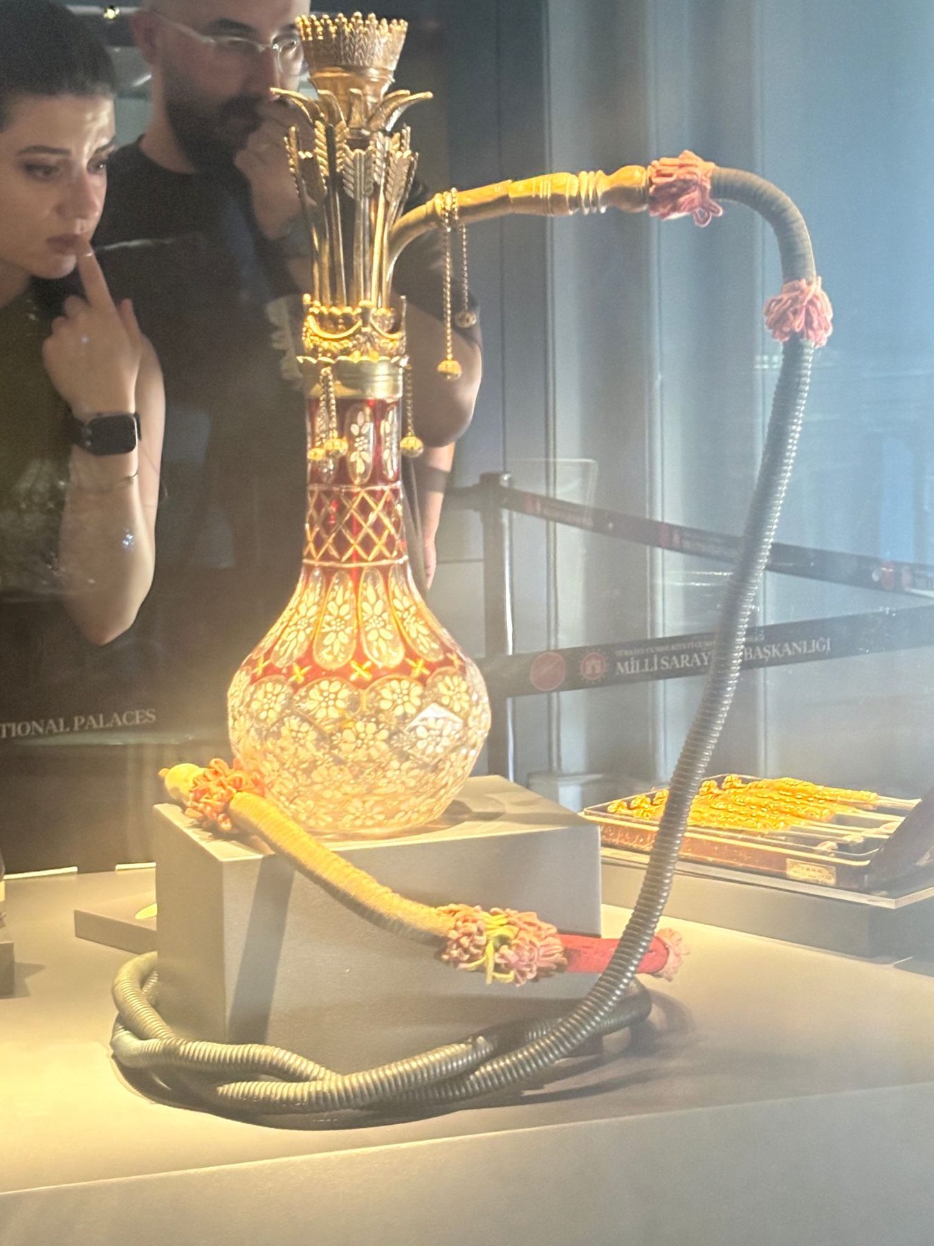 An elaborately decorated nargile water pipe in a display case