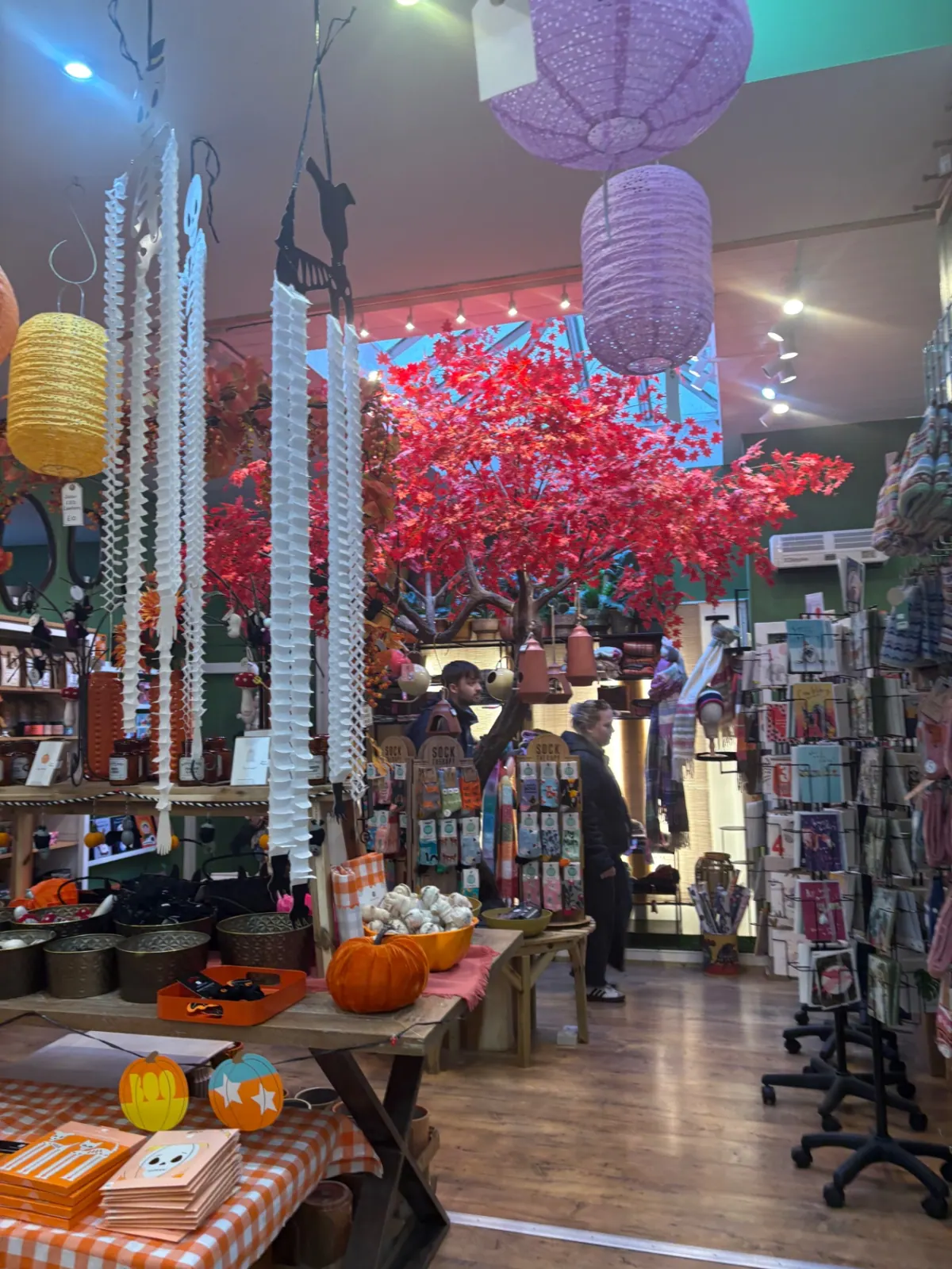 A shop interior full of paper lanterns, pumpkins and autumn decorations