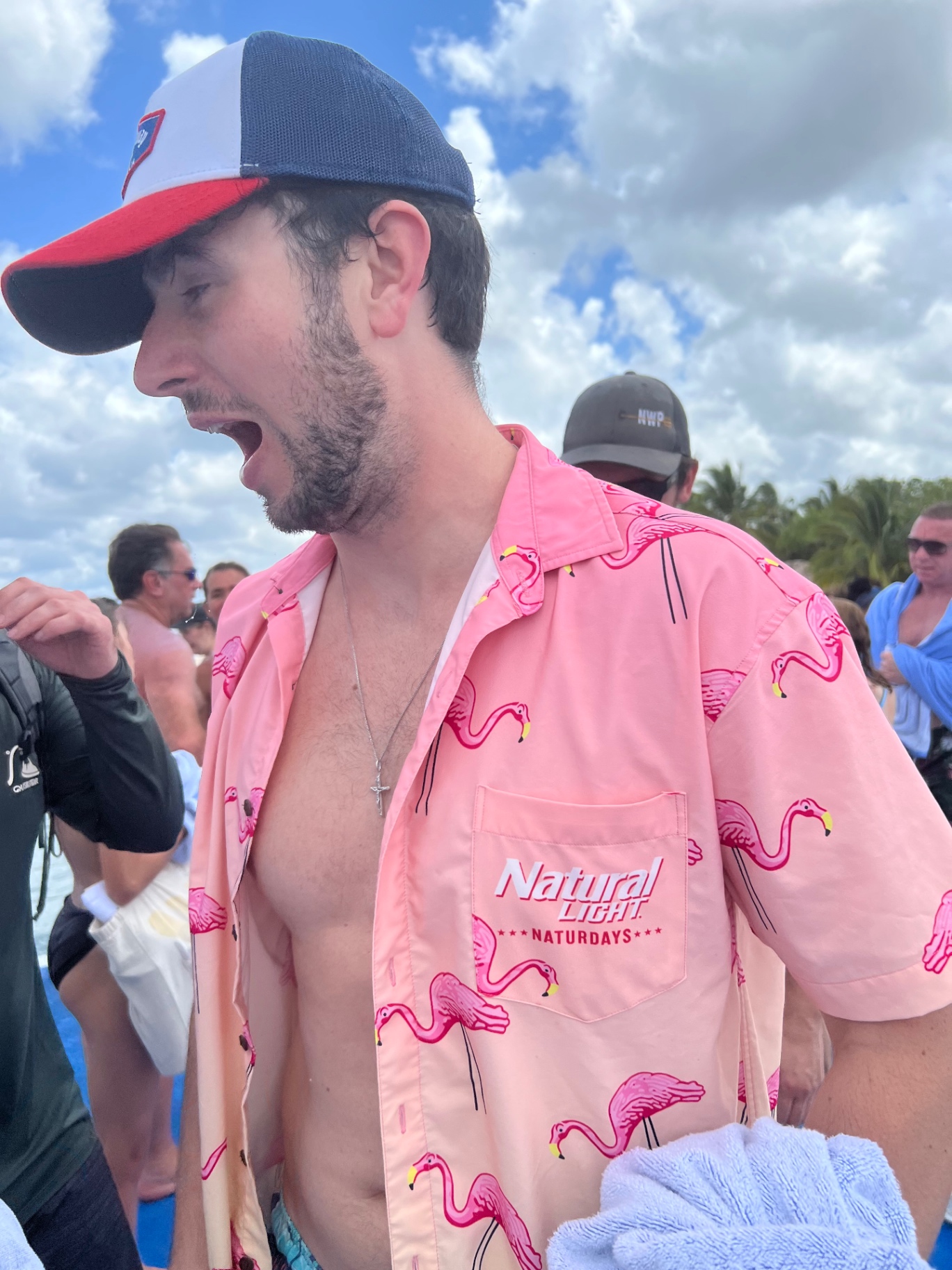 Friend in a pink flamingo shirt mid-cheer on the party boat