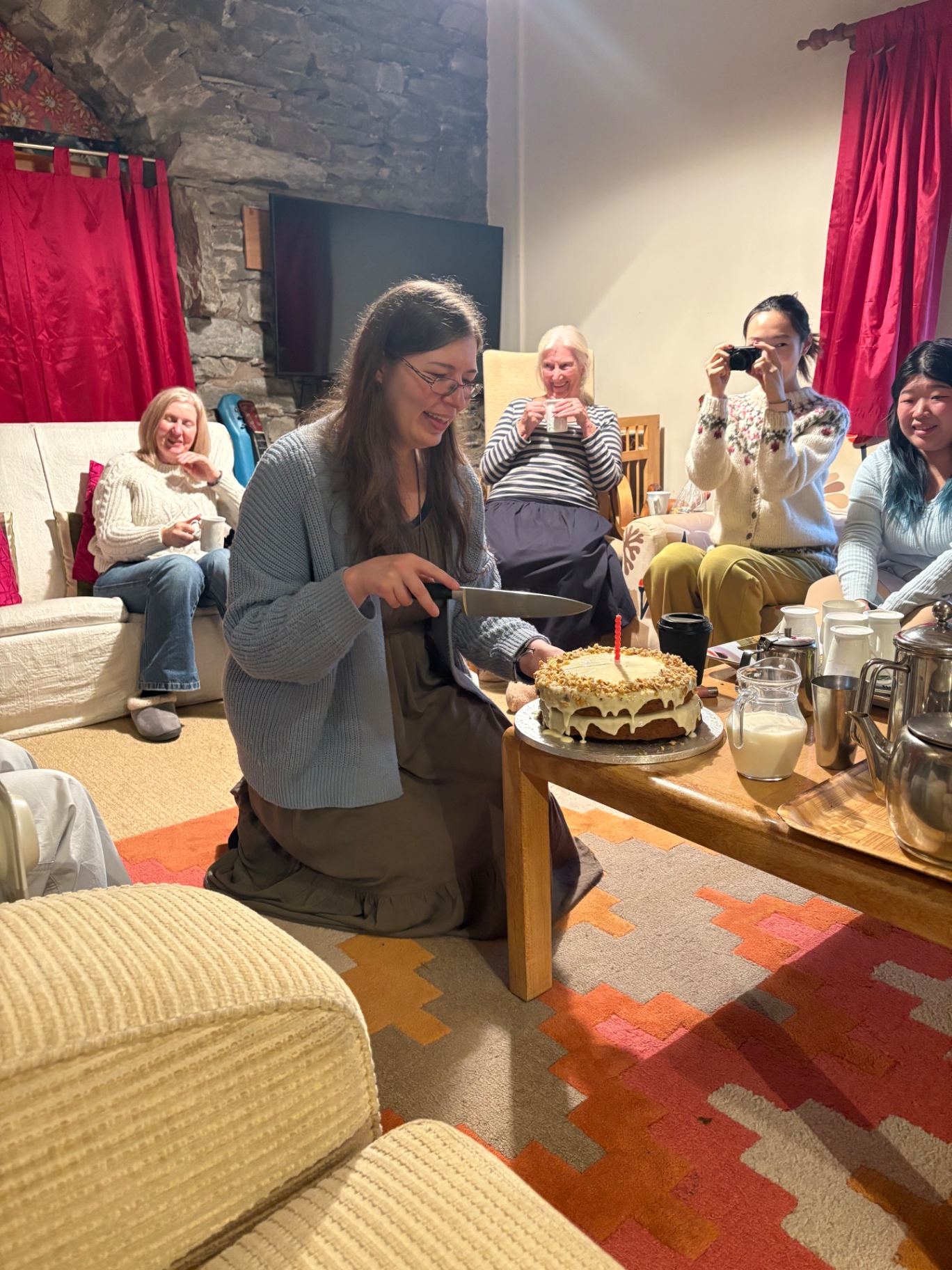 The training group gathered around a birthday cake in the cottage sitting room