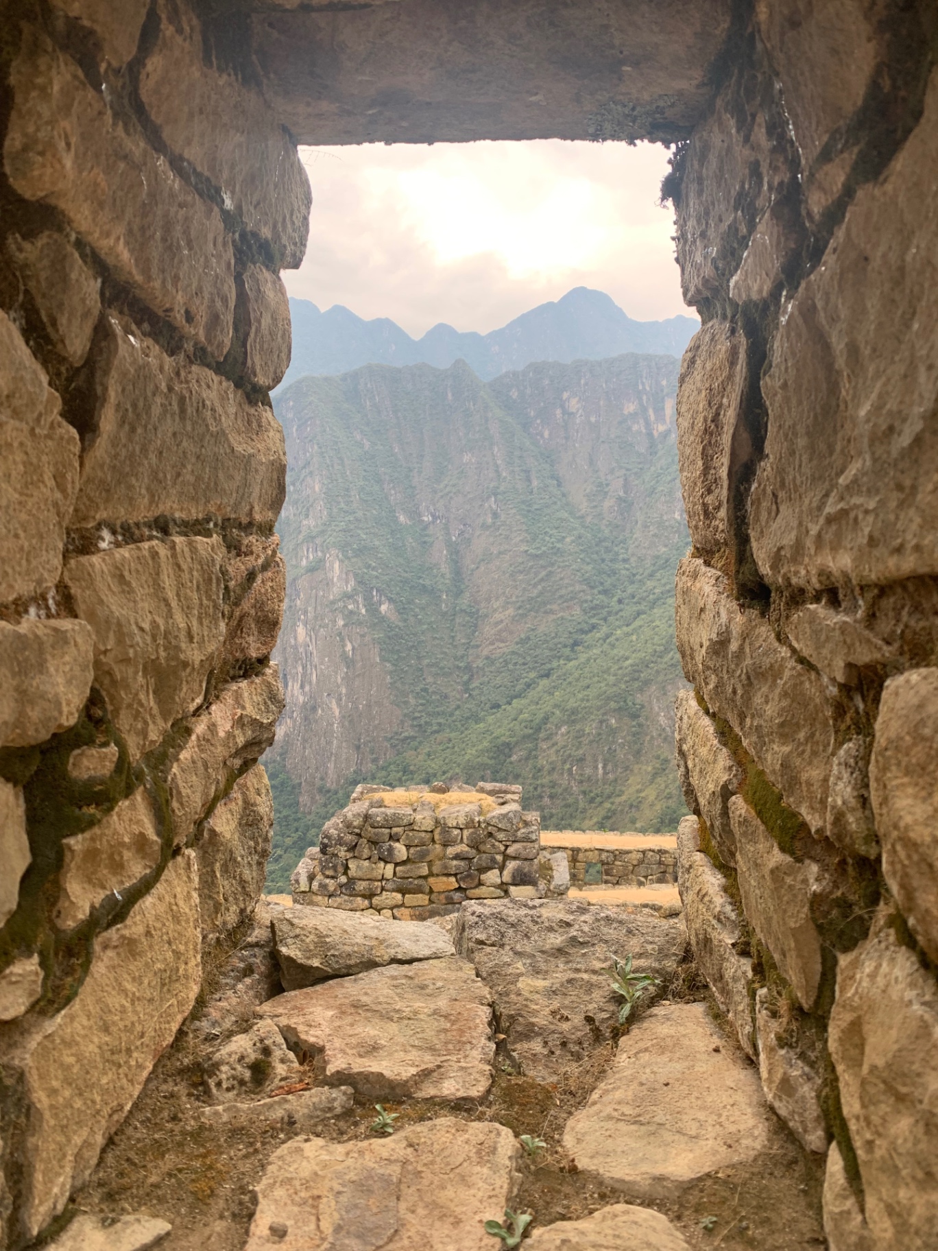 Andean peaks framed through a trapezoidal Inca stone window