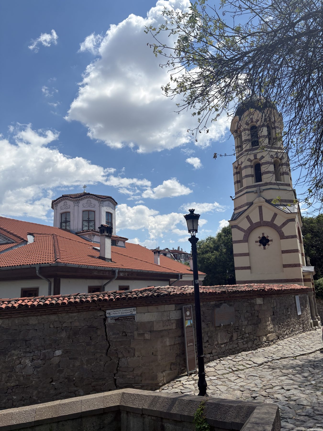 A white and stone bell tower rising above old rooftops
