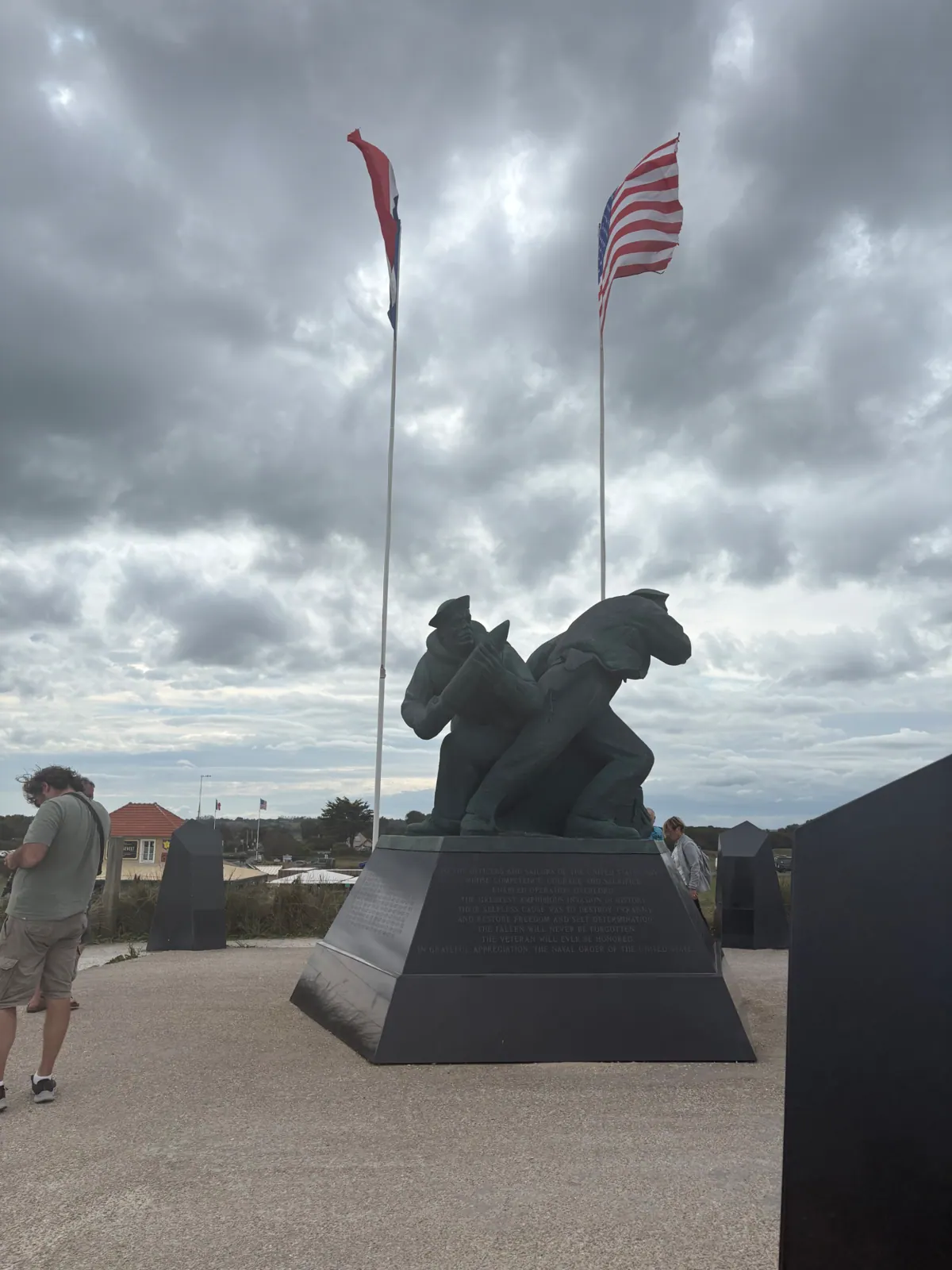 Bronze sculpture of sailors under French and American flags at the US Navy memorial on Utah Beach
