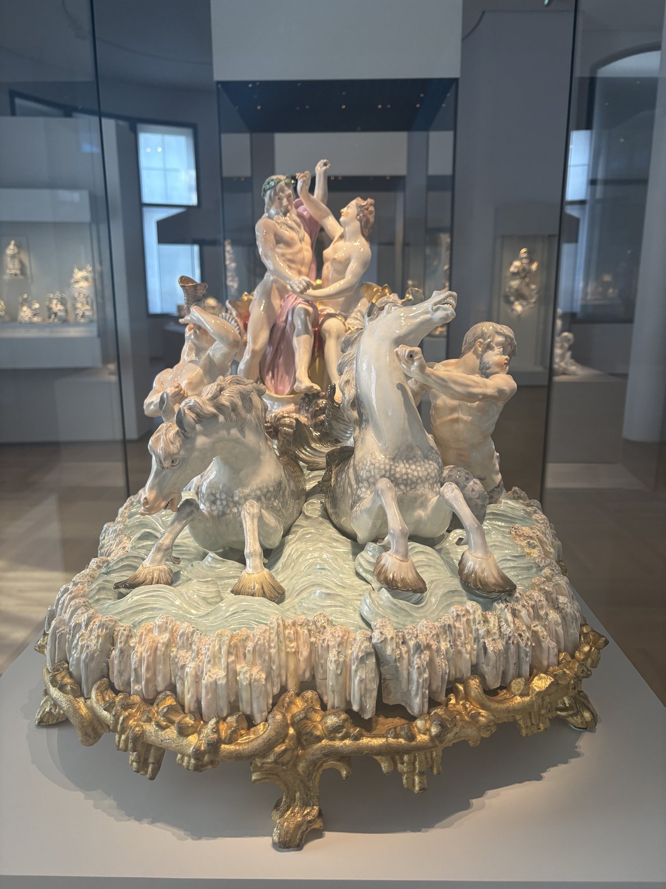 An elaborate painted porcelain group of figures on a rocky base