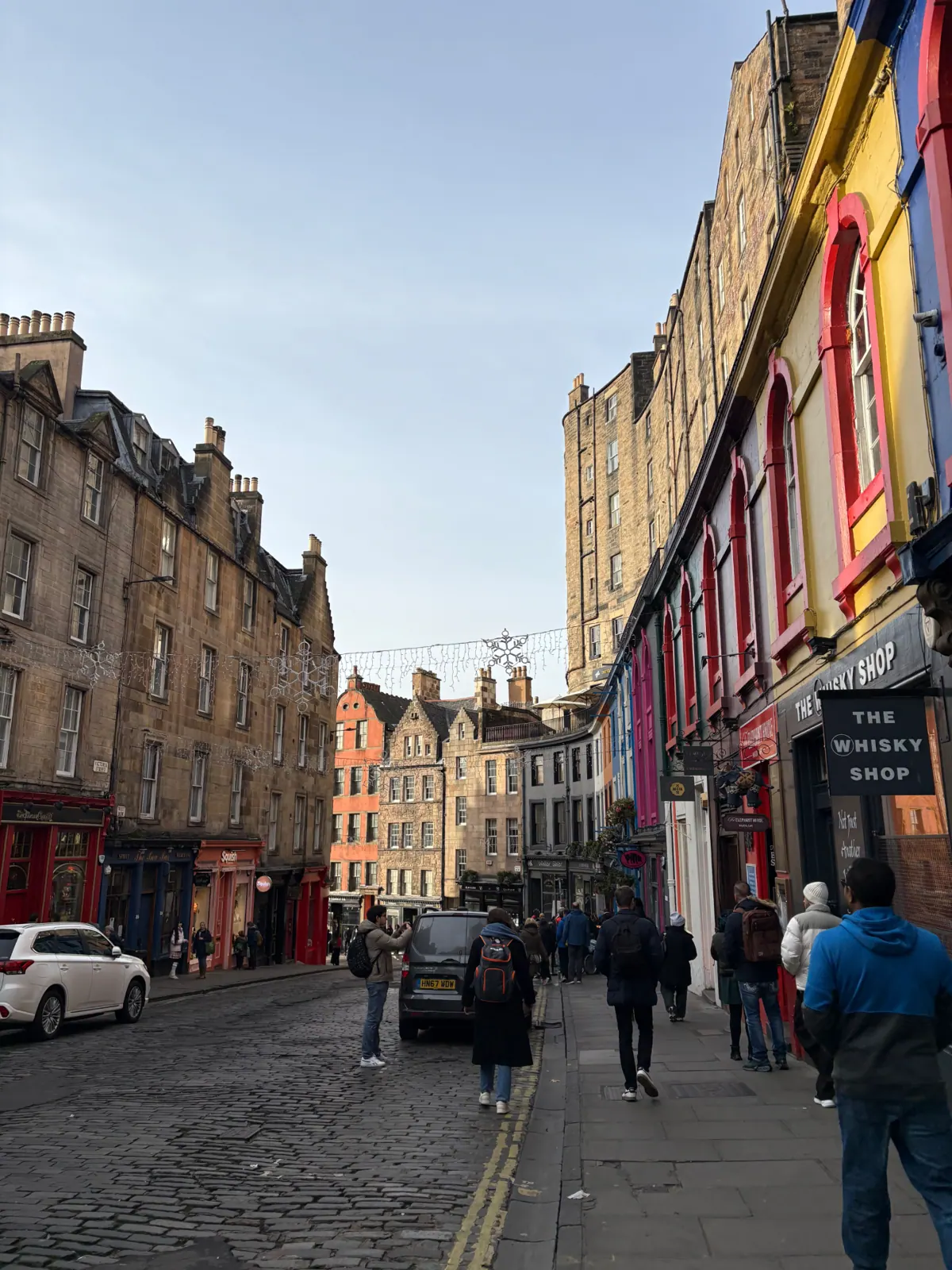 The curving painted shopfronts of Victoria Street with snowflake lights overhead