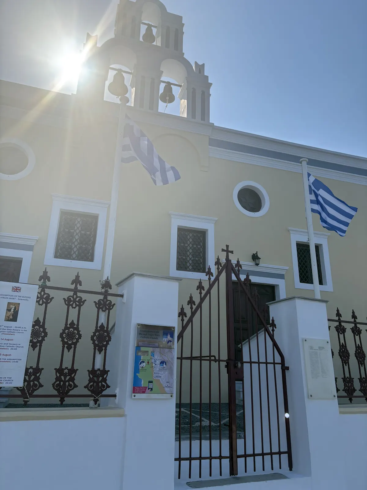 Sunlight behind the bell tower of a Santorini church