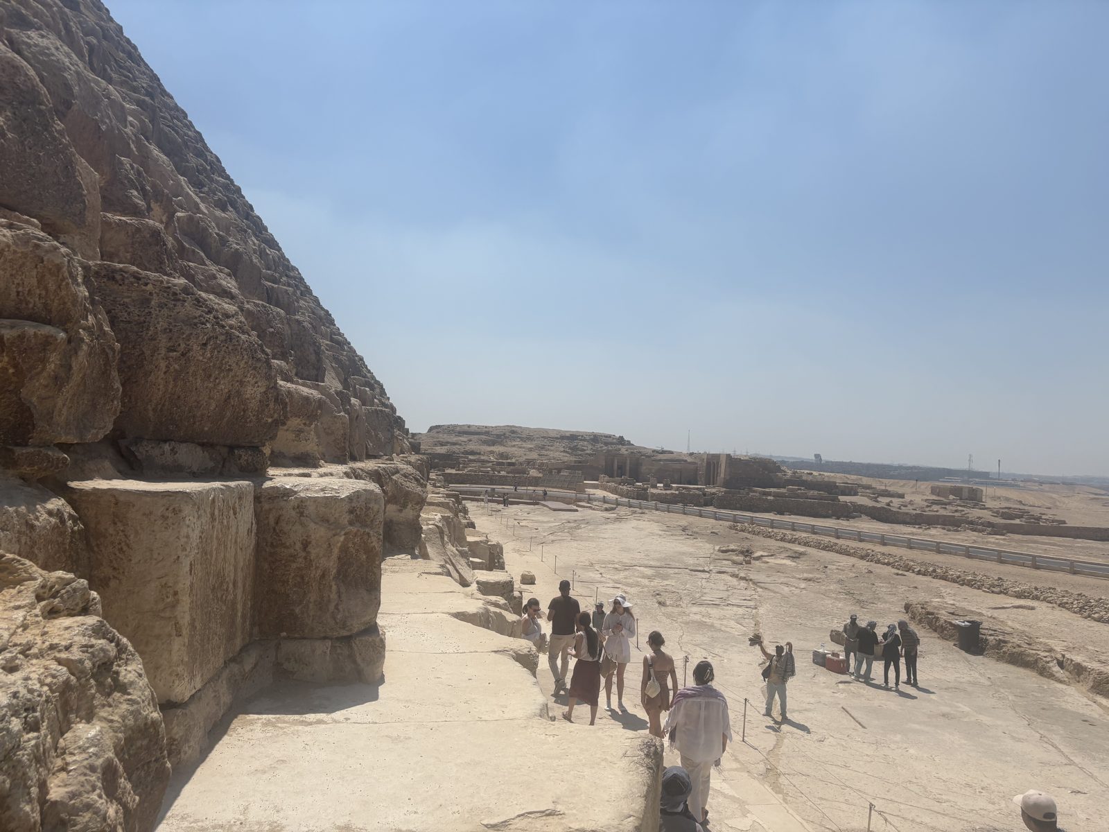 A group of visitors standing at the base of a pyramid at Giza