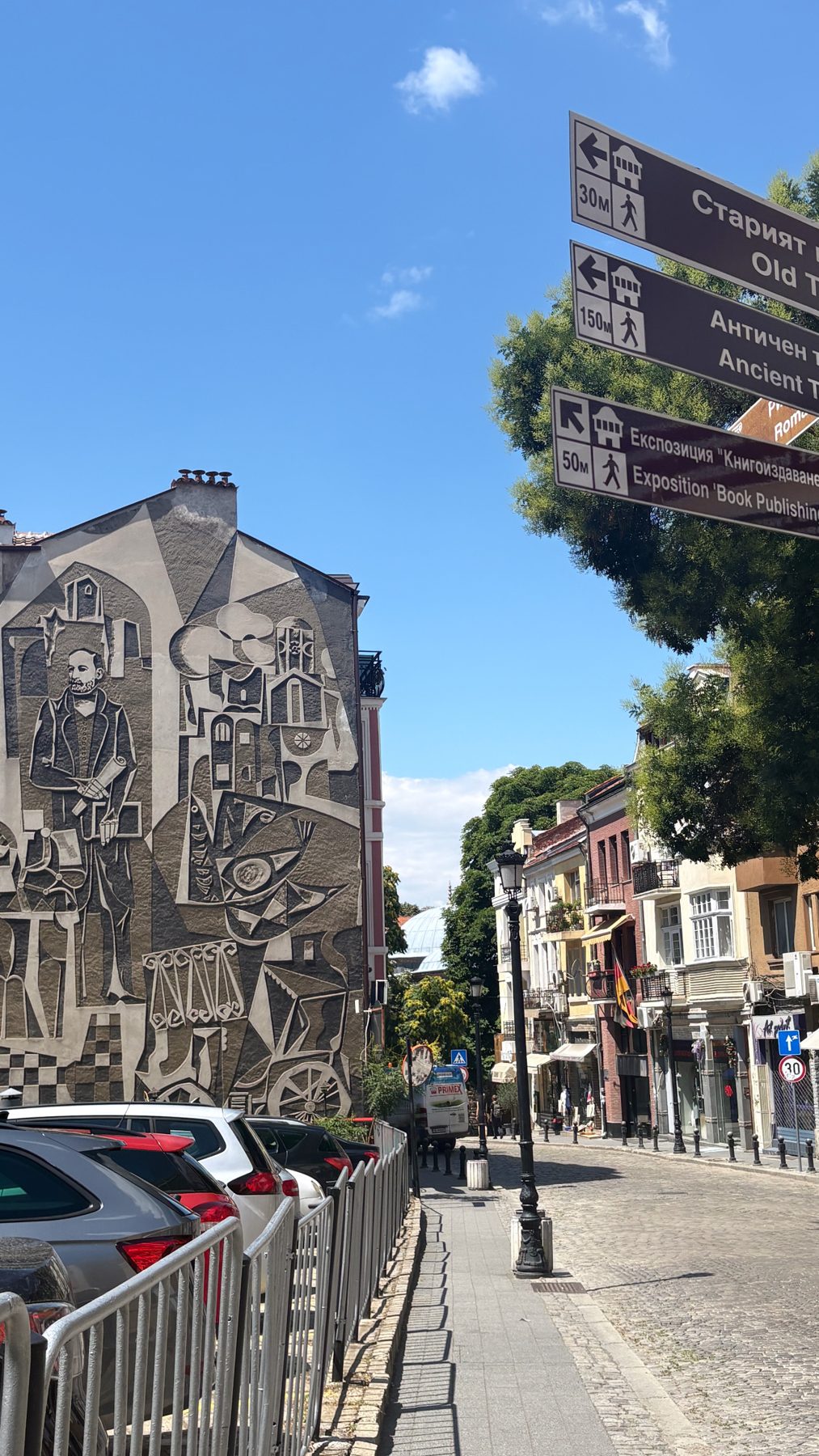 A large carved mural on a building beside a Plovdiv street