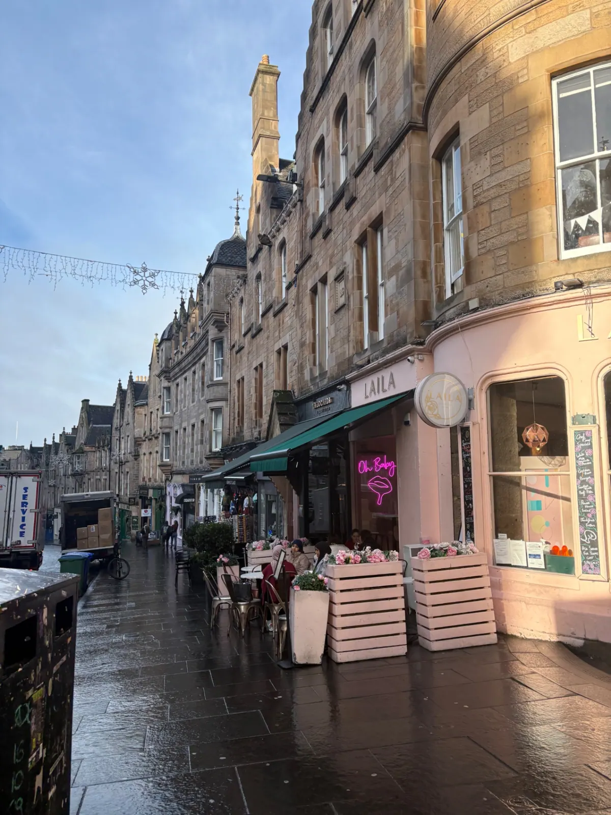 A curving Old Town street with cafés and snowflake lights strung overhead