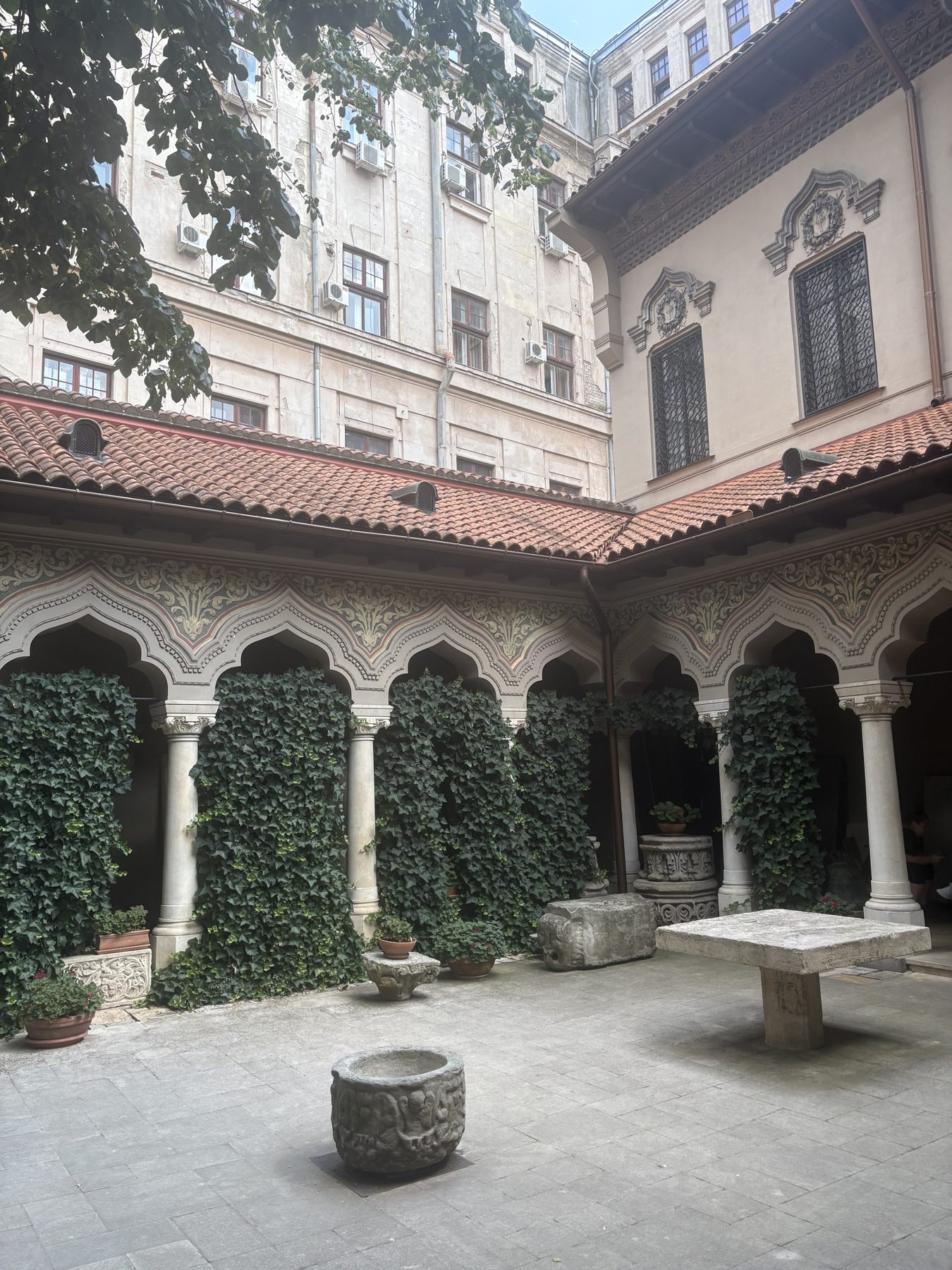 A quiet church courtyard with clipped hedges in Bucharest